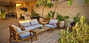 a patio with two chairs and a table and a couch at Riad Dar Haven in Tamraght Ou Fella