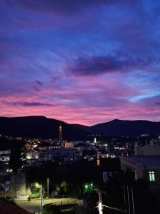 a view of a city at night with a pink at Sunset Home Mostar in Mostar
