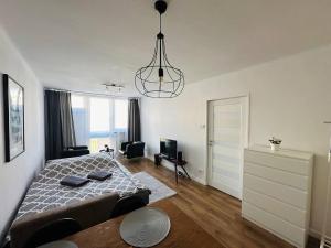 Un dormitorio con una cama y una lámpara de araña. en Warszawa Centralna Rooms, en Varsovia