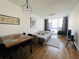 Sala de estar con cama y mesa de comedor en Warszawa Centralna Rooms, en Varsovia