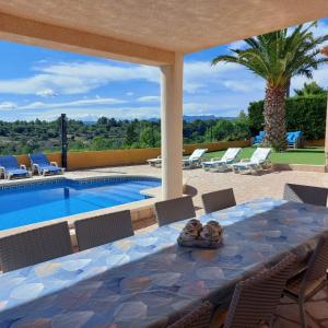 a patio with a table and chairs next to a swimming pool at Buena Vista in L'Ametlla de Mar