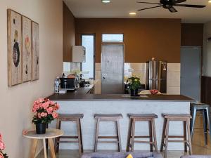 une cuisine avec un bar avec des tabourets et un comptoir dans l'établissement Kensington Sunrise sg, Palas Horizon,kea farm, à Brinchang