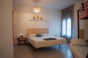 a bedroom with a bed and a couch and a window at El Refugio Valdelinares Gastro Hostal in Valdelinares