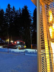 Ein Schneewagen parkt nachts im Schnee. in der Unterkunft STENATA Sport Apartments in Pamporowo