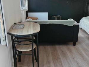 a bed in a room with a table and a chair at Canada 6 in Valenciennes
