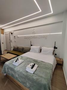 a bedroom with a large bed with two towels on it at ST Luxury Urban Living in Serres