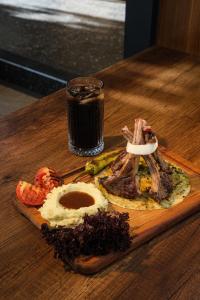 een bord eten op een houten tafel met een drankje bij Yeldeğirmeni Konuk Evi in Istanbul