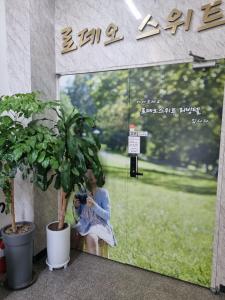高阳市Tanhyun Rodeo Suite Livingtel的一位女士用相机在窗户上拍照