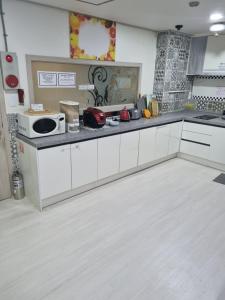 高阳市Tanhyun Rodeo Suite Livingtel的配有白色橱柜和台面的厨房