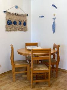 a wooden table and chairs with a table and a curtain at Golden Beach House in Armação de Pêra +10 photos