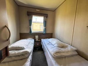 two beds in a small room with a window at Brilliant 8 Berth Caravan At Reighton Sands Holiday Park, Haven Ref 61053Rc in Filey +7 photos