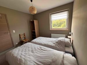 a bedroom with two beds and a window at El Rozère in Cerfontaine