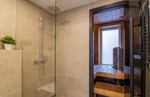 a glass shower in a bathroom with a window at Lai Residence Apartment 3 with Sauna in Tartu +14 photos