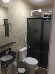 Un baño con inodoro, ducha y lavabo. en Melquiades Hotel, en Patos