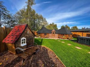 a small house with a red roof in a yard at Bespoke Holiday Home With Private Pool And Hot Tub, Sleeps 8 Ref 34073P in Kings Lynn