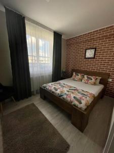 a bedroom with a bed and a brick wall at Demure Terrace Apartment in Bucharest
