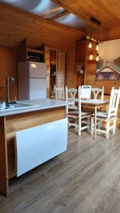 a kitchen and dining room with a table and chairs at Appartement mansardé cocooning in Saint-Martin-Vésubie