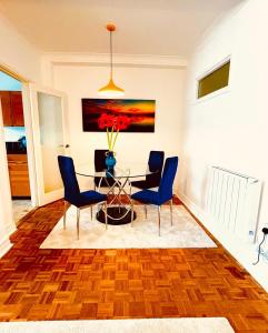 a dining room with a table and blue chairs at Cosy 2 bedroom Apartment 2 min to Hyde Park in London +7 photos