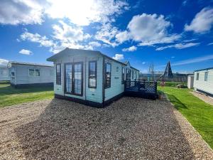 a tiny house sitting on gravel in a yard at Great 4 Berth Caravan For Hire In Suffolk At North Denes, Ref 40149Nd in Lowestoft