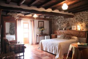a bedroom with a bed and a stone wall at Casa Lucia in Mogarraz