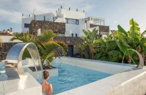 a boy in a swimming pool in front of a building at Finca Marisa in Tinajo
