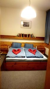 ein Bett mit zwei roten Kissen darüber in der Unterkunft Appartements Central in Bad Kleinkirchheim