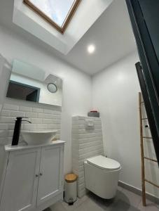 ein weißes Badezimmer mit Waschbecken und Toilette in der Unterkunft R- Maison 6 chambres 3 min metro 10 lits PARC EXPO in Arcueil