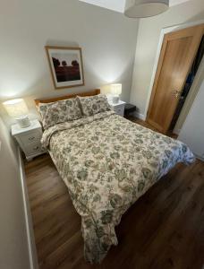 a bedroom with a bed with a floral bedspread and two lamps at Taobh na Farraige in Belmullet