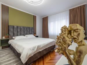 锡比乌MSC Apartment的一间带大床和雕像的卧室