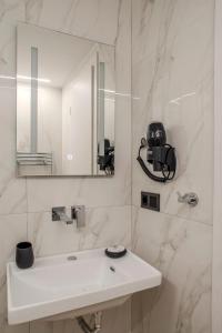 a white bathroom with a sink and a mirror at City Lodge in Thessaloniki
