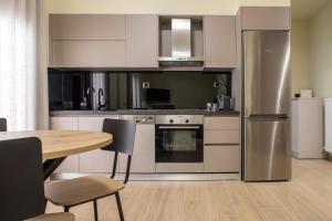 a kitchen with a table and a stainless steel refrigerator at City Lodge in Thessaloniki