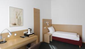 ニュームブレヒトにあるKaspers Gästehausのベッドと机のある小さな部屋