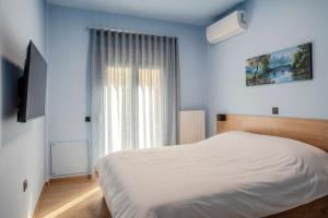 a bedroom with a white bed and a window at City Lodge in Thessaloniki