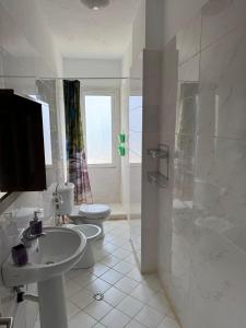 a bathroom with a sink and a toilet and a shower at Natali Apartments in Gjilek +32 photos