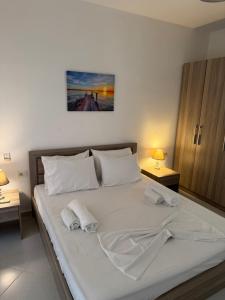 a bedroom with a large white bed with two towels at Natali Apartments in Gjilek