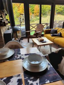 a living room with a table and a yellow couch at Ski & Spa Bungalows in Kopaonik