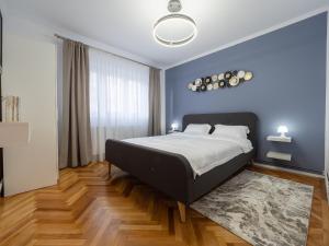 a bedroom with a bed and a blue wall at MSC Apartment in Sibiu