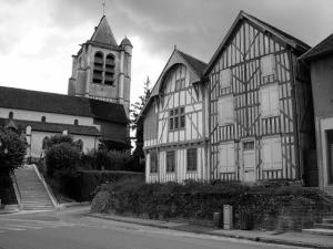 a black and white photo of a building with a church at Meublé de tourisme Le Gilliard in Chavanges
