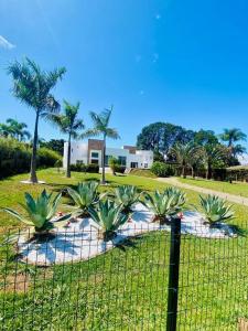 a fence in front of a park with palm trees at Casa-Condomínio-Itu-City Castelo in Itu +48 photos