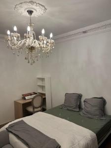 a bedroom with a chandelier and a bed at BX - Maison 10 rooms - 12 beds - metro PARIS EXPO in Montrouge