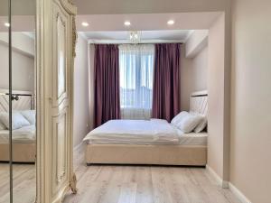 a bedroom with a bed and a large mirror at Premium Residence, steps to center Arbat, drinking water as a gift in Almaty