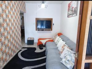 a living room with a couch and a tv at Casa Souza in Ilhéus