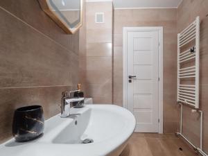a bathroom with a white sink and a mirror at MSC Apartment in Sibiu +16 photos
