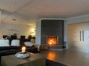 een woonkamer met een bank en een open haard bij Villa Kaja mit Pool, Kamin und traumhaftem Blick auf den Möhnesee in Delecke