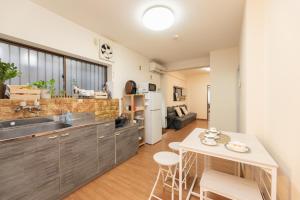 a kitchen with a sink and a table with chairs at Osaka Kanzakigawa Royal駅徒步1分 "private house 3 bed rooms "一棟貸し宿 in Osaka