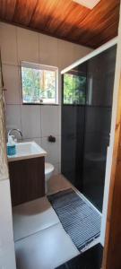 a bathroom with a shower and a sink and a toilet at Paraíso das Flores in Abraão +8 photos