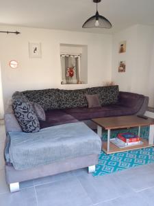 a living room with a couch and a table at gite au calme centre finistère jardin clos in Trégourez