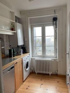 eine Küche mit Waschmaschine und Fenster in der Unterkunft La PetiteVillaise in Granville