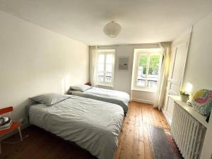 ein Schlafzimmer mit zwei Betten und einem Fenster in der Unterkunft La PetiteVillaise in Granville
