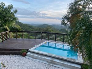 a swimming pool on a deck with mountains in the background at La Kolina Reserve in Ponce